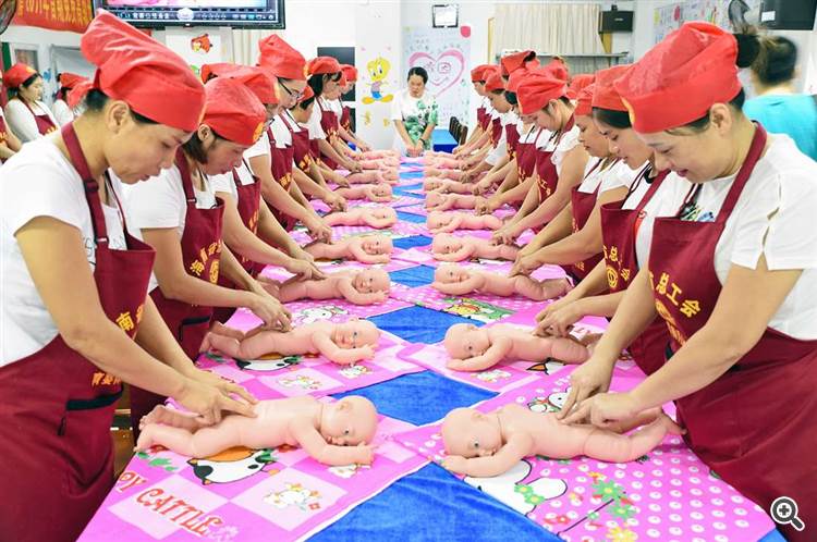 Donne a un corso di formazione gratuito sulla cura dei bambini organizzato da un sindacato locale a Haikou. Provincia di Hainan, Cina